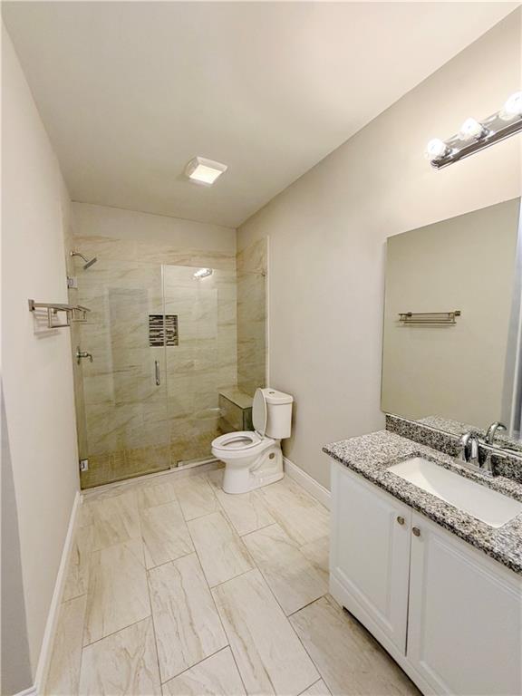 5296 Cheval Rue Court Suwanee, GA 30024 - Photo 40 of 51 a bathroom with a granite countertop sink a toilet and shower