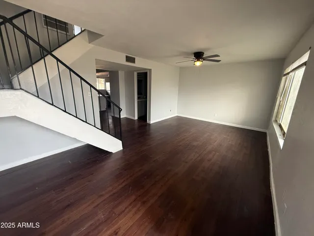 a view of a hallway with wooden floor and staircase