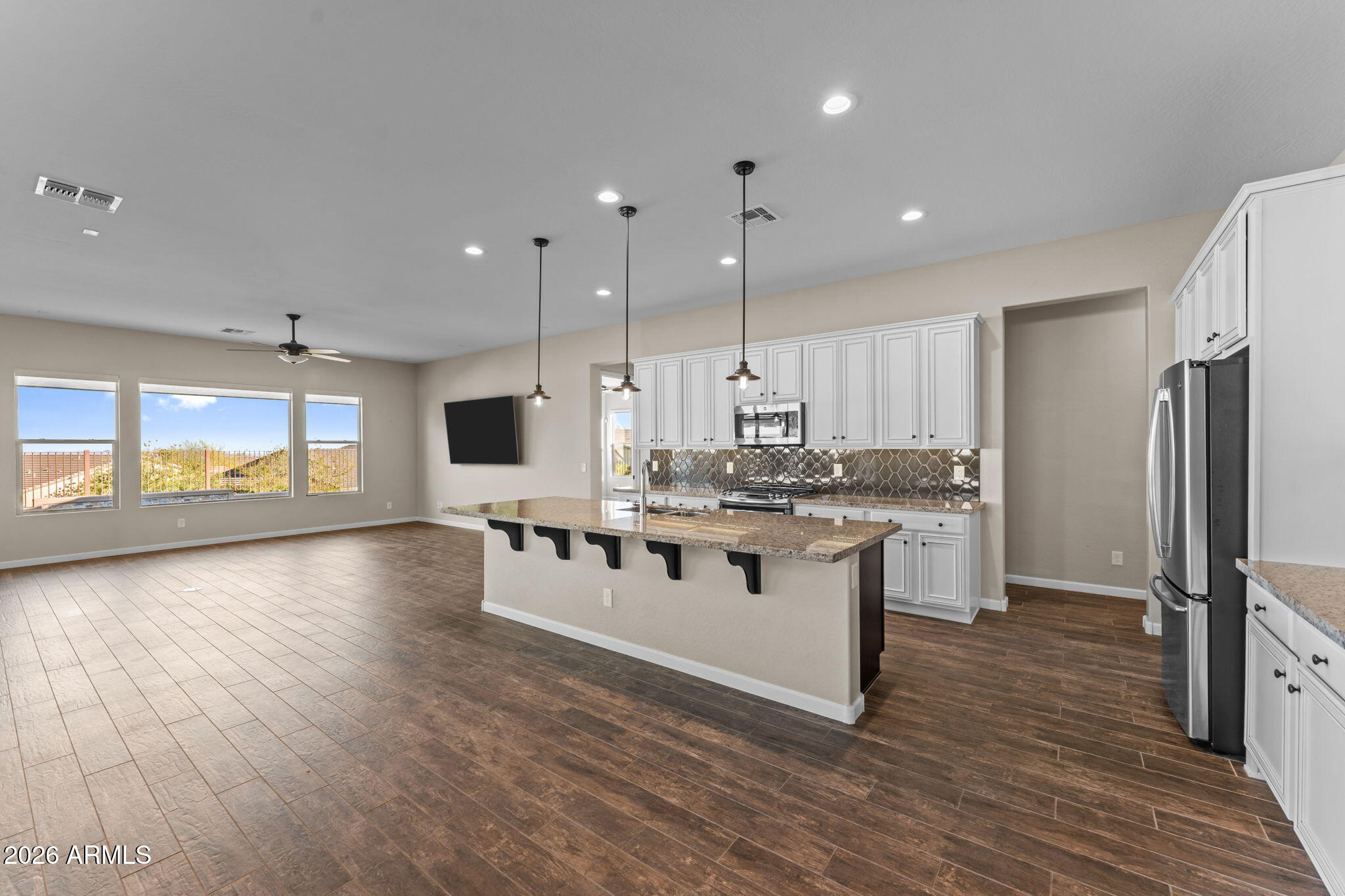 3675 Gold Ridge Road Wickenburg, AZ 85390 - Photo 16 of 58 a kitchen with stainless steel appliances granite countertop a stove top oven a sink dishwasher a refrigerator and white cabinets with wooden floor