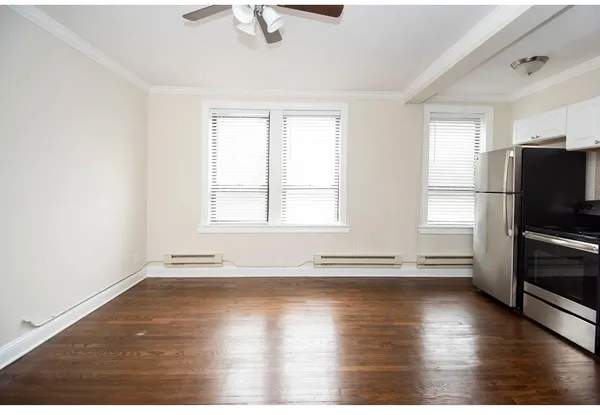 a view of empty room with wooden floor and window
