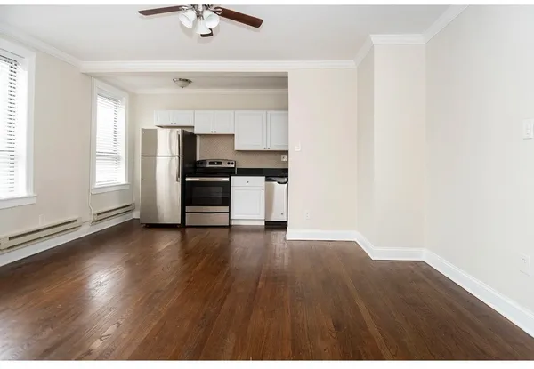 a view of a kitchen with a sink stove cabinets and empty room