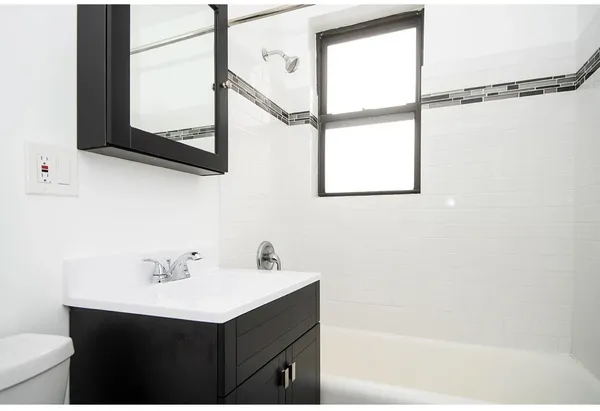 a bathroom with a sink and mirror with window