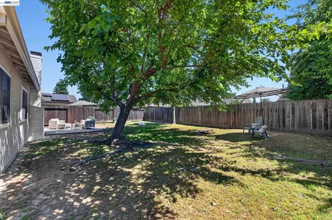a backyard of a house with table and chairs