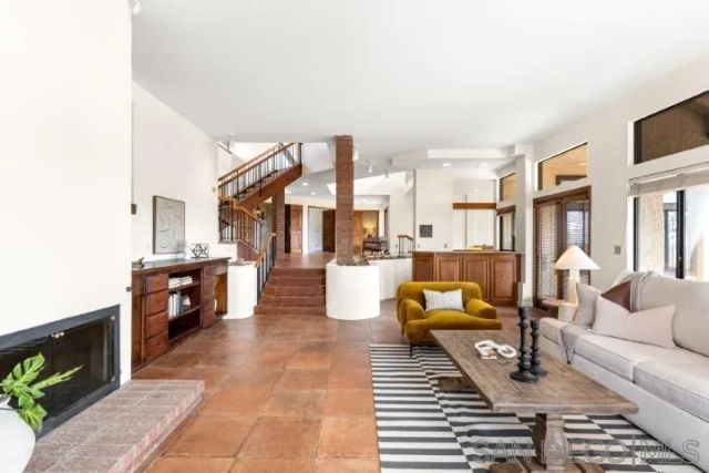 a living room with fireplace furniture and a large window