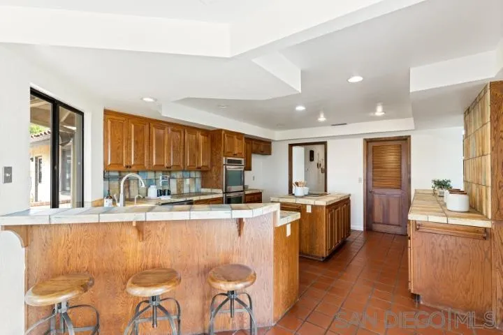 3253 Yucca Terrace Fallbrook, CA 92028 - Photo 25 of 62 a kitchen with stainless steel appliances granite countertop a stove a sink dishwasher and a refrigerator with wooden cabinets