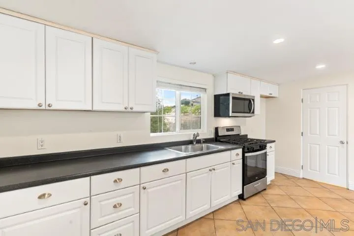 3253 Yucca Terrace Fallbrook, CA 92028 - Photo 56 of 62 a kitchen with granite countertop white cabinets and a sink