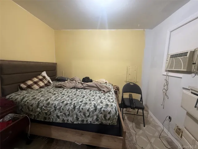 a bed sitting in a bedroom next to a window with pc on the wall