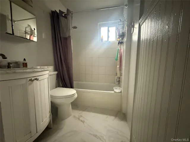 a bathroom with a granite countertop toilet a sink and a mirror