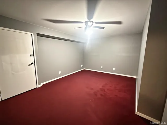 an empty room with a ceiling fan and wooden floor