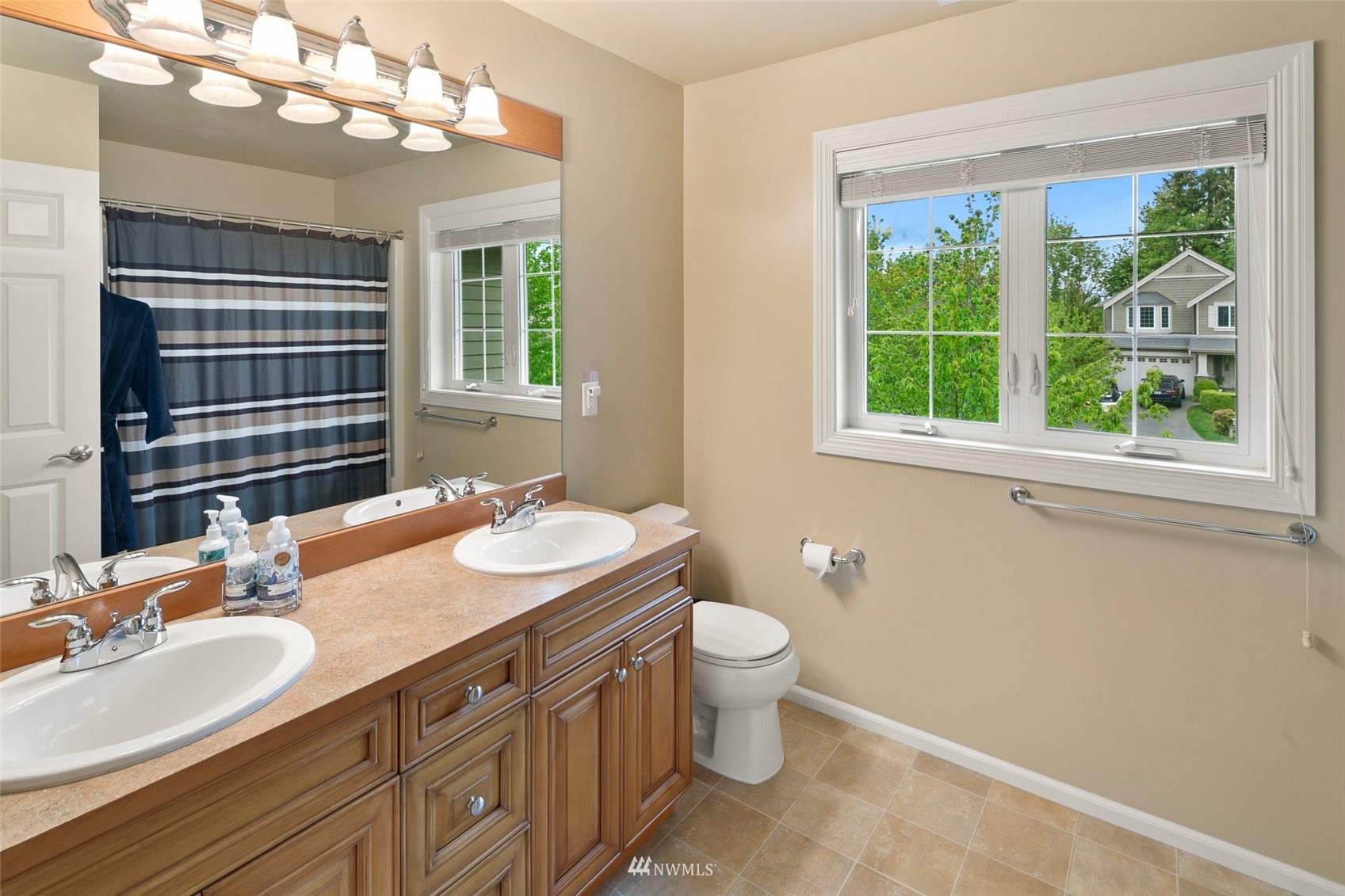 4202 221st Place Southeast Bothell, WA 98021 - Photo 21 of 28 a bathroom with a granite countertop sink a large mirror a vanity and a window