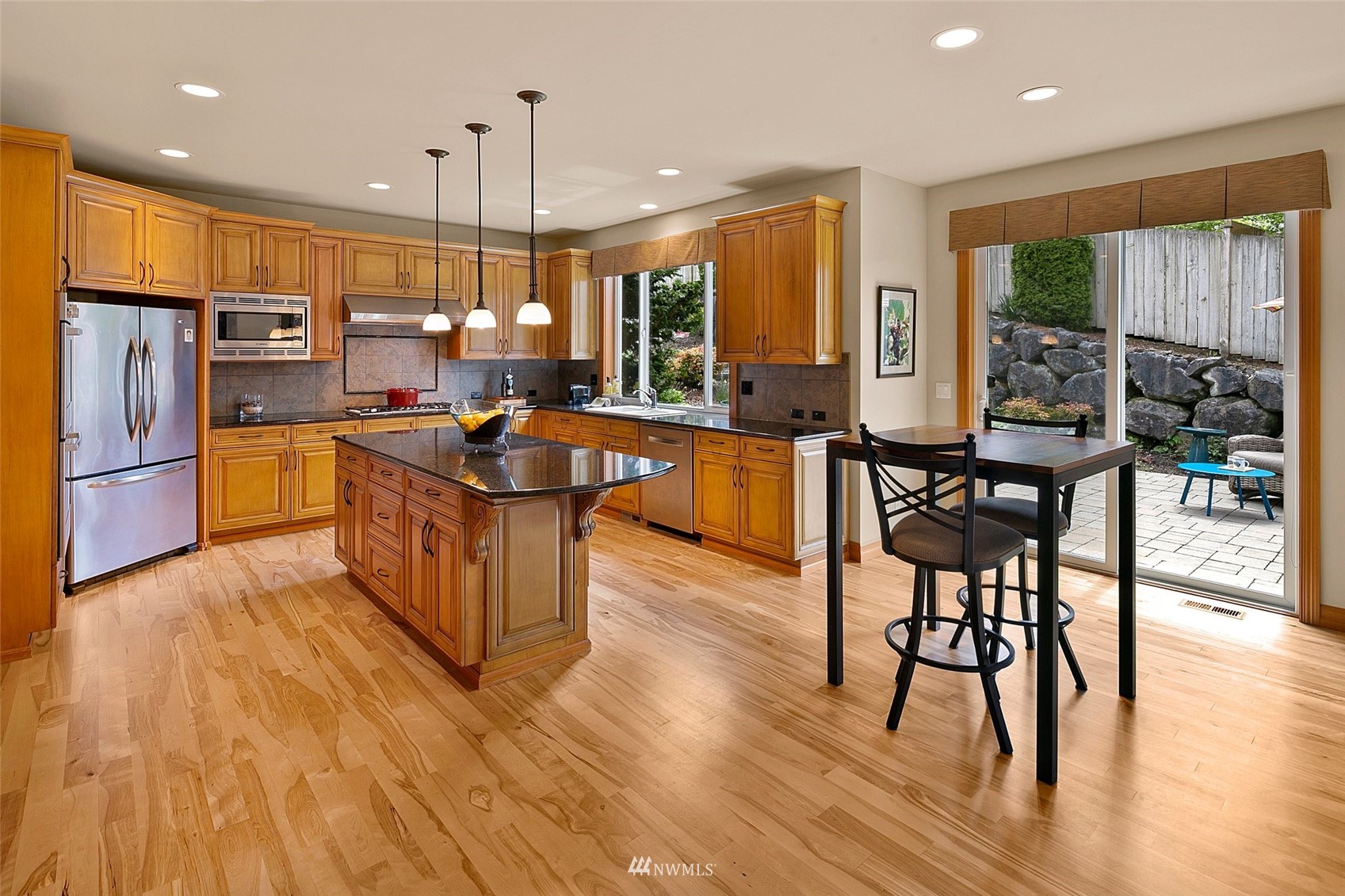 4202 221st Place Southeast Bothell, WA 98021 - Photo 8 of 28 a kitchen with stainless steel appliances granite countertop a table chairs and a refrigerator