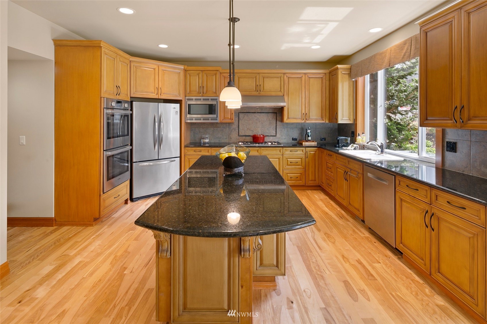 4202 221st Place Southeast Bothell, WA 98021 - Photo 10 of 28 a kitchen with stainless steel appliances granite countertop a sink refrigerator and cabinets