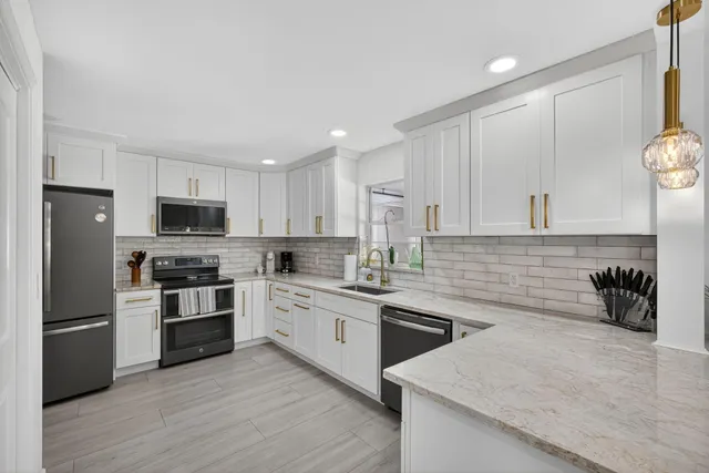a kitchen with white cabinets sink and stainless steel appliances