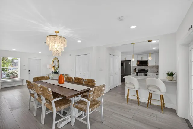 a kitchen with stainless steel appliances granite countertop a stove top oven a sink and dishwasher a refrigerator with wooden floor