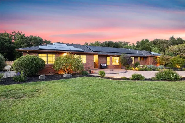 a front view of a house with a yard and potted plants