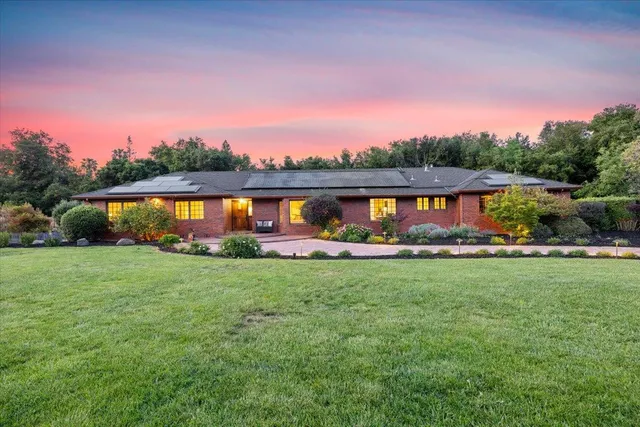 a large kitchen with granite countertop a large counter top stainless steel appliances and windows