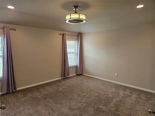 an empty room with closet and a chandelier fan