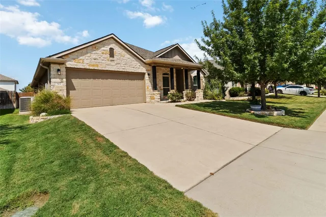 a front view of a house with a yard and trees