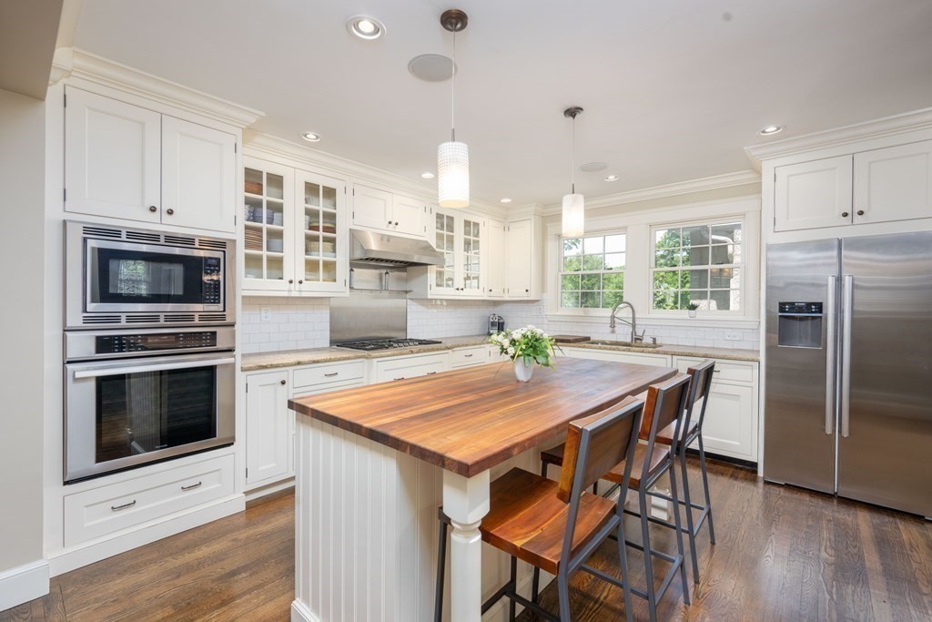 a kitchen with kitchen island a wooden floor and white appliances