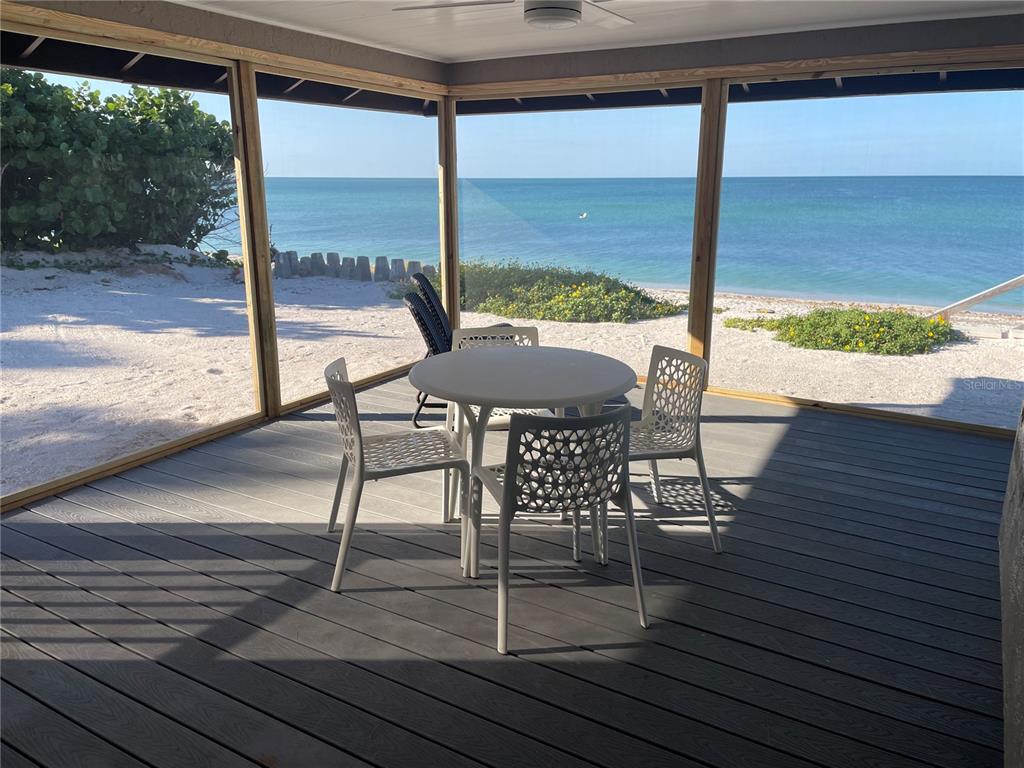 2709 Casey Key Road Nokomis, FL 34275 - Photo 20 of 64 a view of a patio with a table chairs and wooden floor