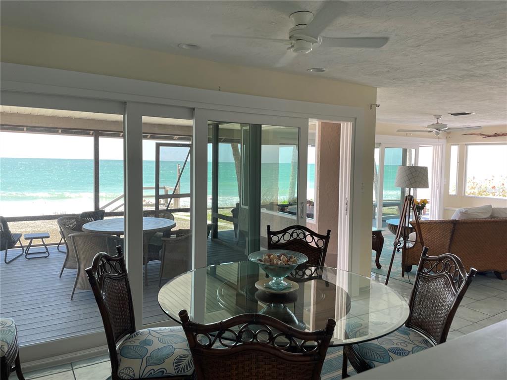 2709 Casey Key Road Nokomis, FL 34275 - Photo 22 of 40 a dining room with furniture a chandelier and wooden floor