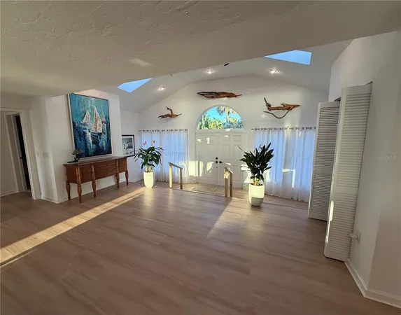 a kitchen with stainless steel appliances a refrigerator a sink a stove a dining table and chairs