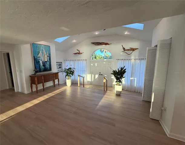 a kitchen with stainless steel appliances a refrigerator a sink a stove a dining table and chairs