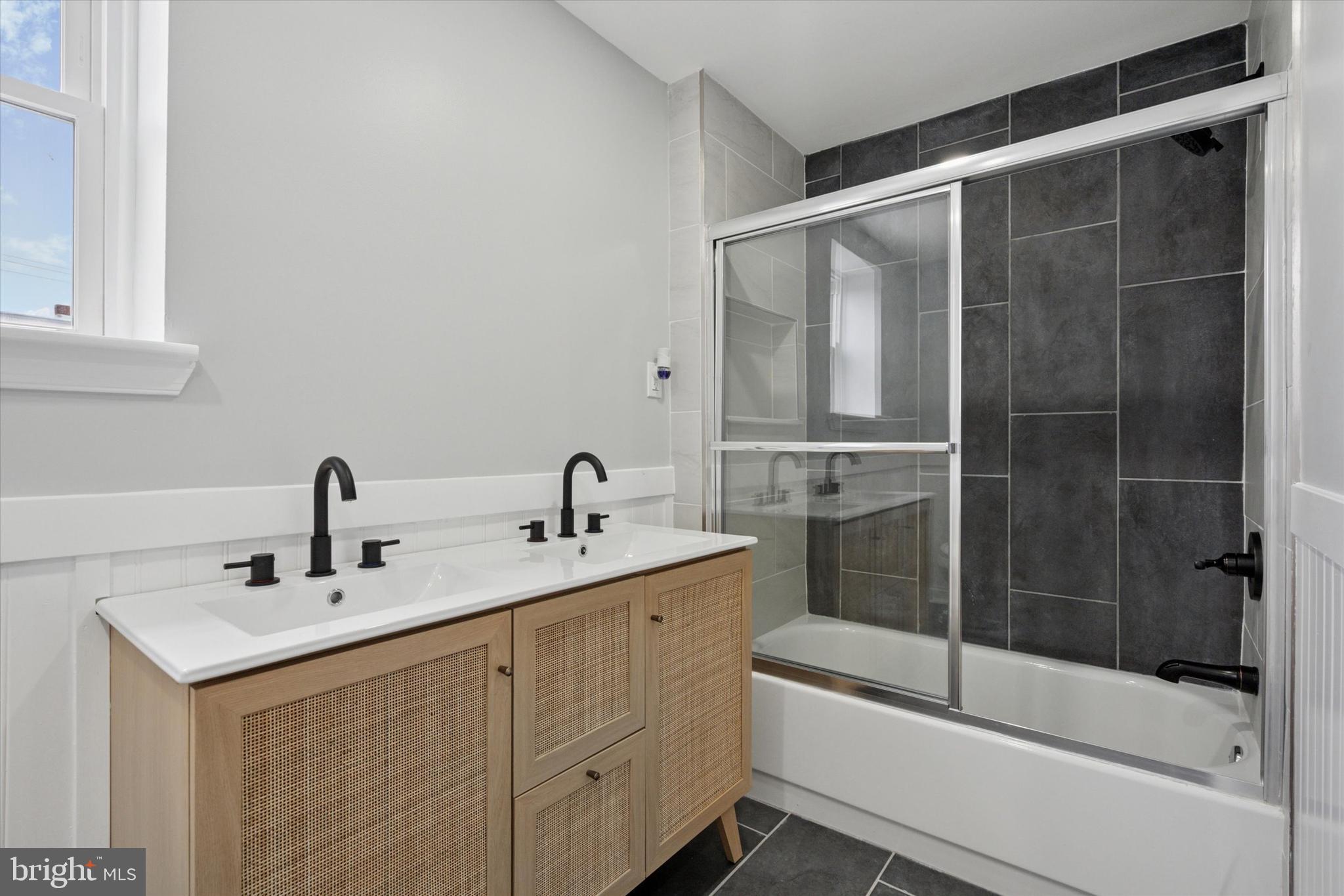 3448 Amber Street Philadelphia, PA 19134 - Photo 24 of 29 a bathroom with a shower sink vanity and mirror