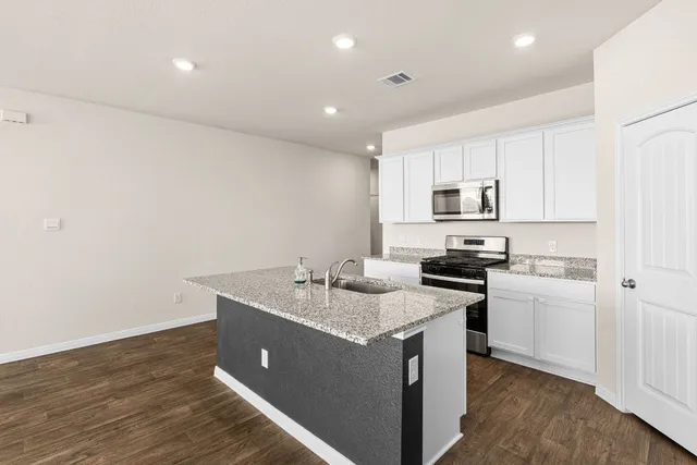 a kitchen with stainless steel appliances granite countertop a sink stove and refrigerator