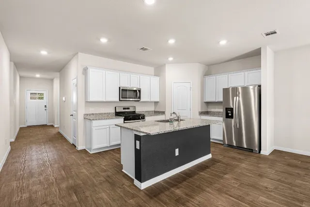a kitchen with stainless steel appliances a stove refrigerator sink and microwave