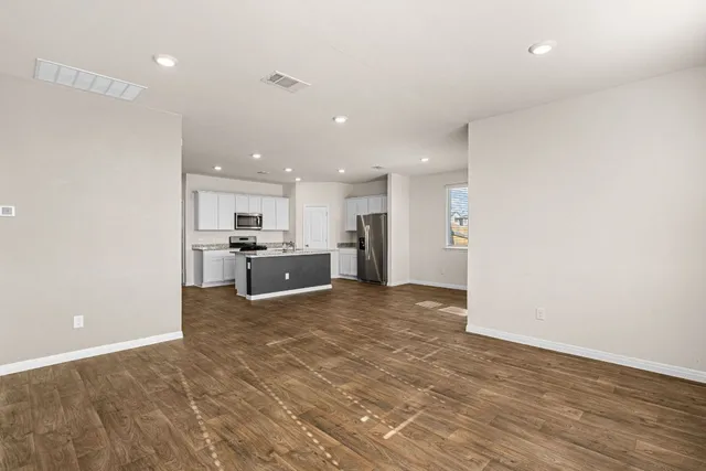 a view of kitchen with kitchen island a sink a stove and a refrigerator