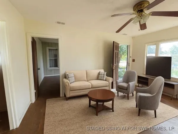 a living room with furniture a ceiling fan and a rug