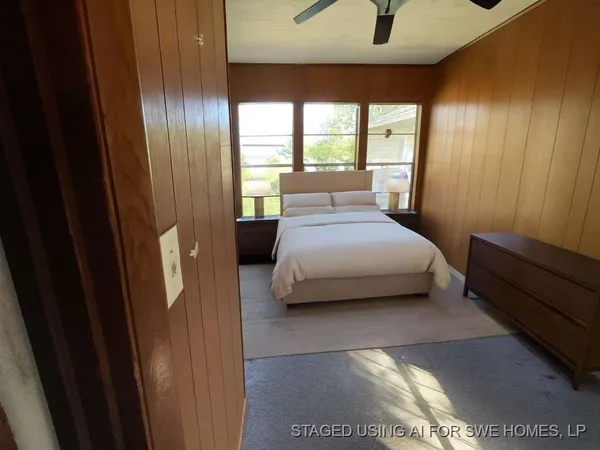 a bedroom with a bed and large window