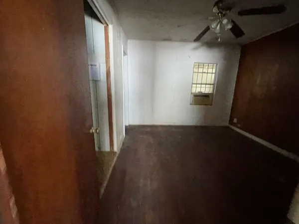 a view of a room with wooden floor and a window