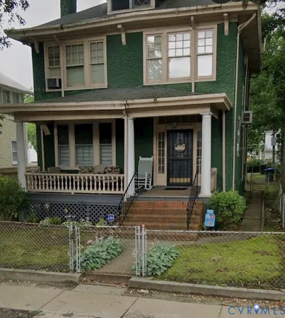 a view of a brick house with plants and large windows