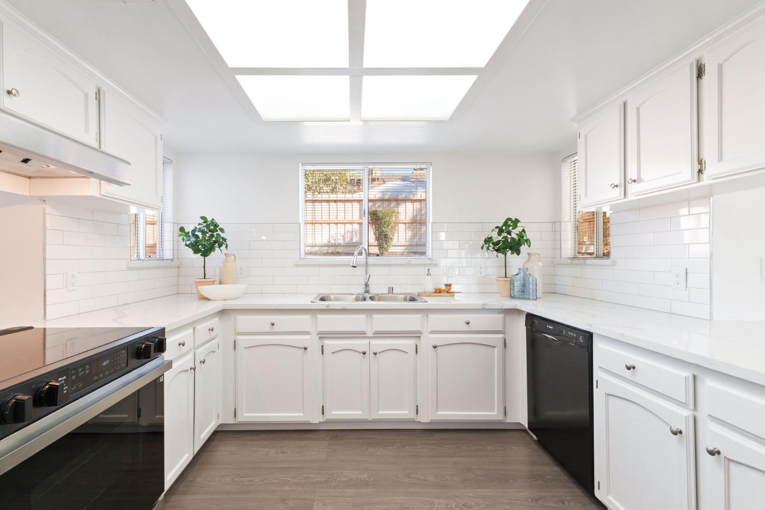 9342 North Archie Avenue Fresno, CA 93720 - Photo 11 of 36 a kitchen with a sink stove cabinets and wooden floor