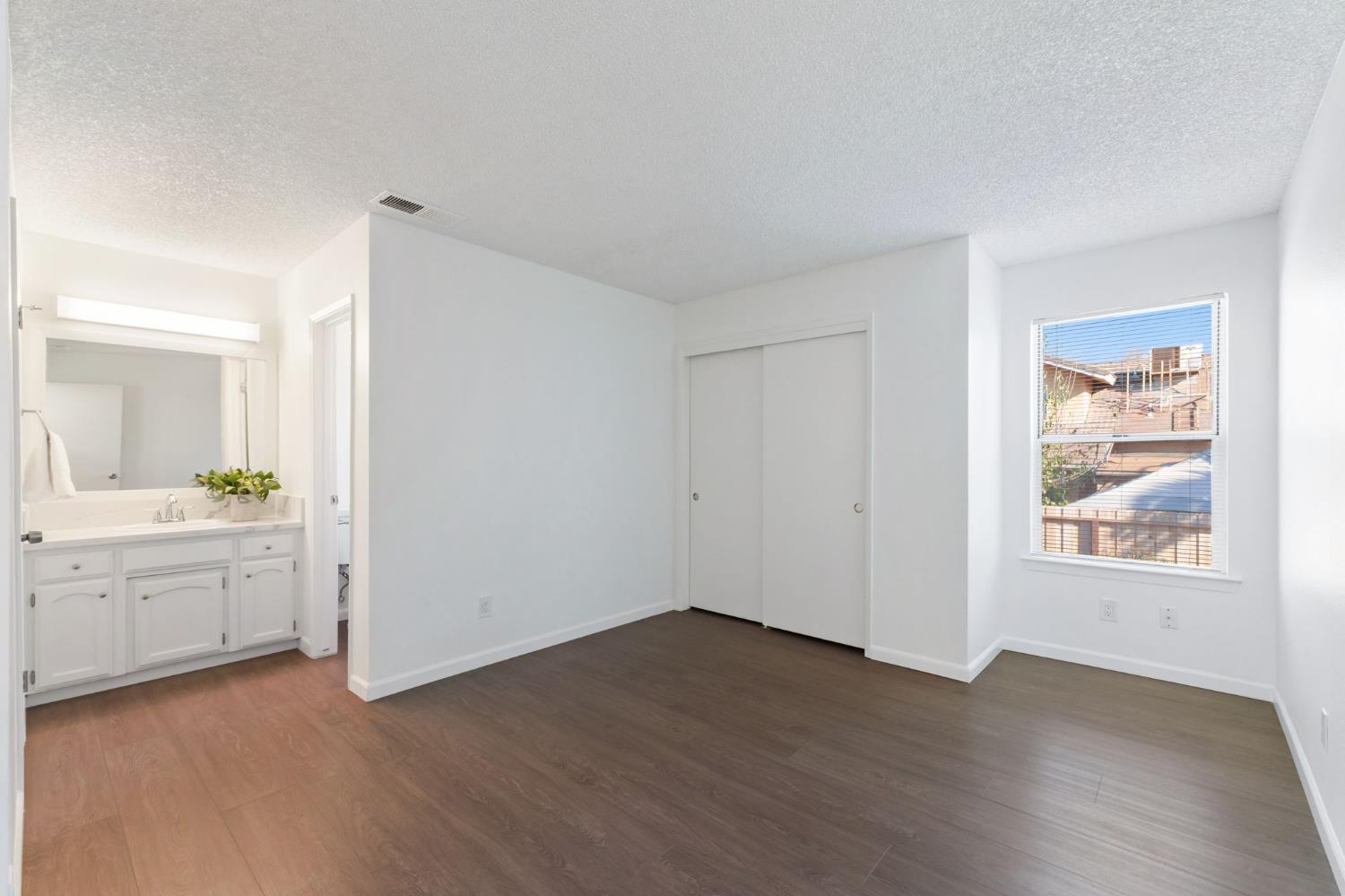 9342 North Archie Avenue Fresno, CA 93720 - Photo 21 of 36 an empty room with wooden floor and window