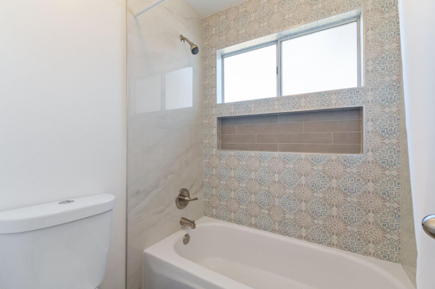 9342 North Archie Avenue Fresno, CA 93720 - Photo 24 of 36 a bathroom with a bathtub and window