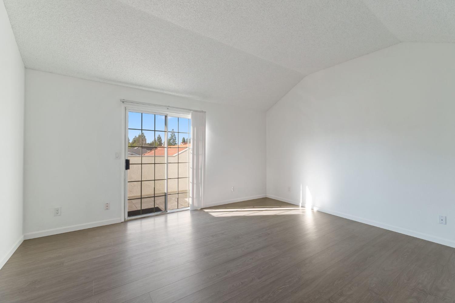 9342 North Archie Avenue Fresno, CA 93720 - Photo 25 of 36 a view of an empty room with wooden floor and a window