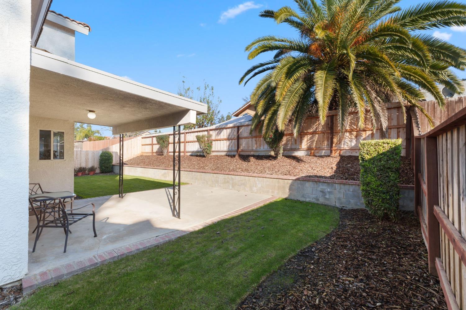 9342 North Archie Avenue Fresno, CA 93720 - Photo 33 of 36 a view of a backyard with plants and palm tree