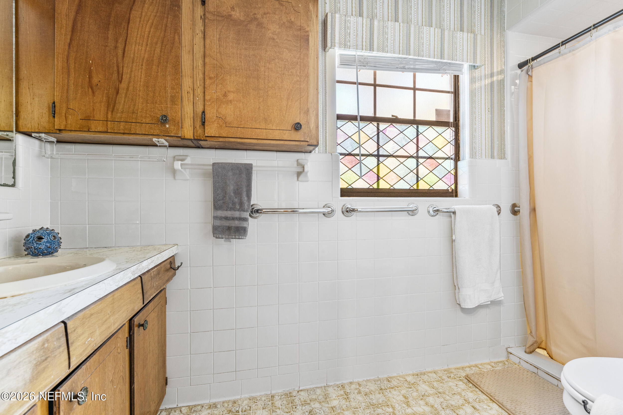 701 16th Street St. Augustine, FL 32080 - Photo 18 of 39 a bathroom with a sink and a window