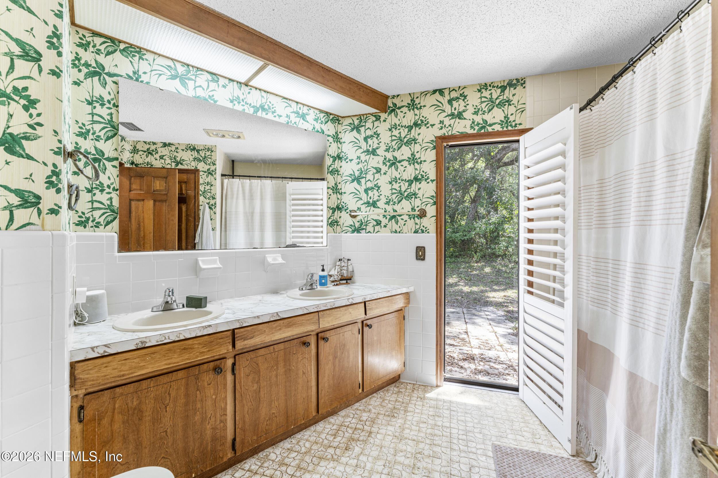 701 16th Street St. Augustine, FL 32080 - Photo 26 of 39 a bathroom with a double vanity sink and a mirror