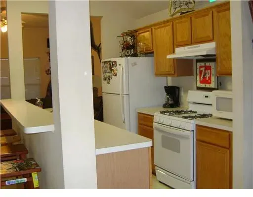 a kitchen with a refrigerator and a stove top oven