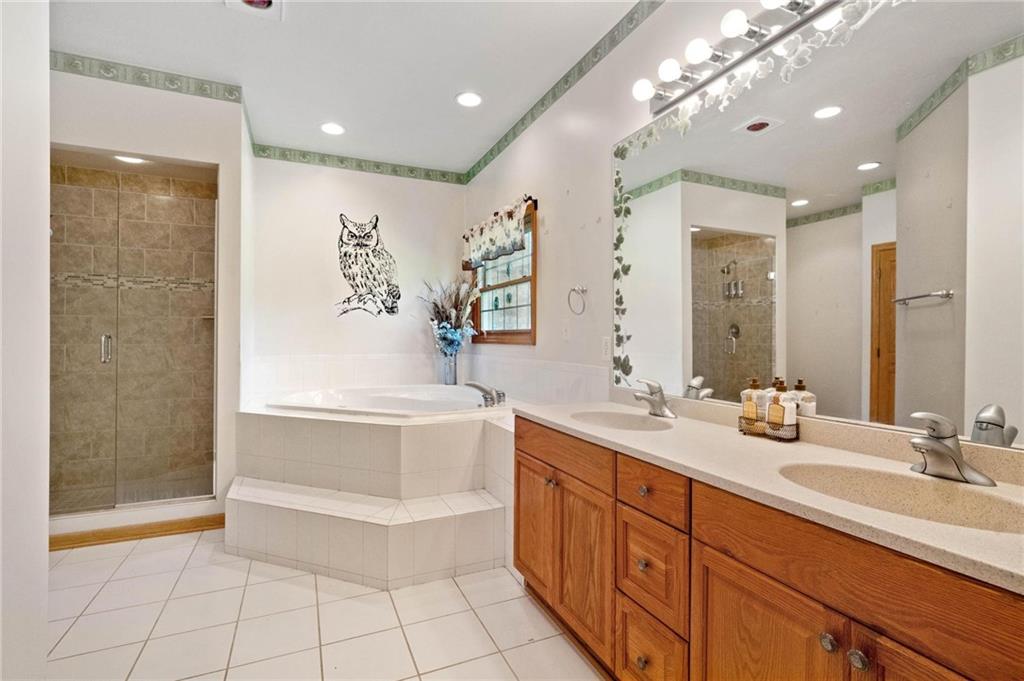 216 Marshall Road Oakdale, PA 15071 - Photo 13 of 25 a bathroom with a double vanity sink large mirror and a bathtub