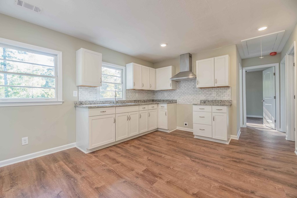 4810 Toney Drive Columbus, GA 31903 - Photo 6 of 17 a kitchen with stainless steel appliances granite countertop a stove a sink dishwasher and a refrigerator with wooden floors
