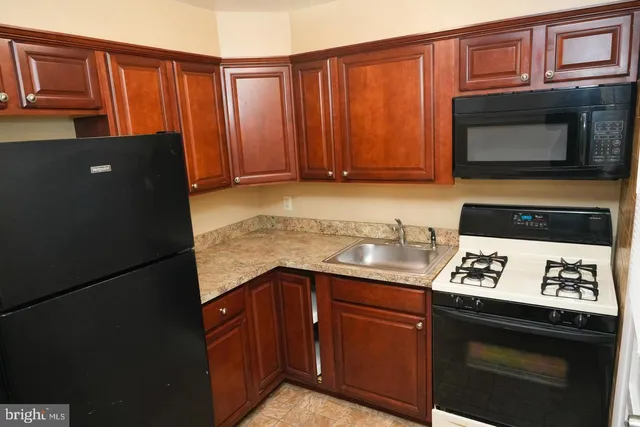 a kitchen with granite countertop stainless steel appliances a stove microwave and refrigerator