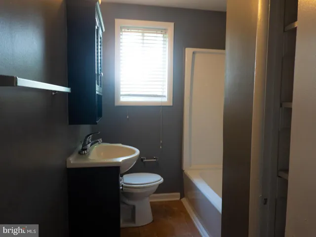 a bathroom with a toilet sink and mirror