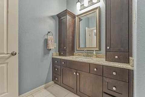 a bathroom with a granite countertop sink and a mirror