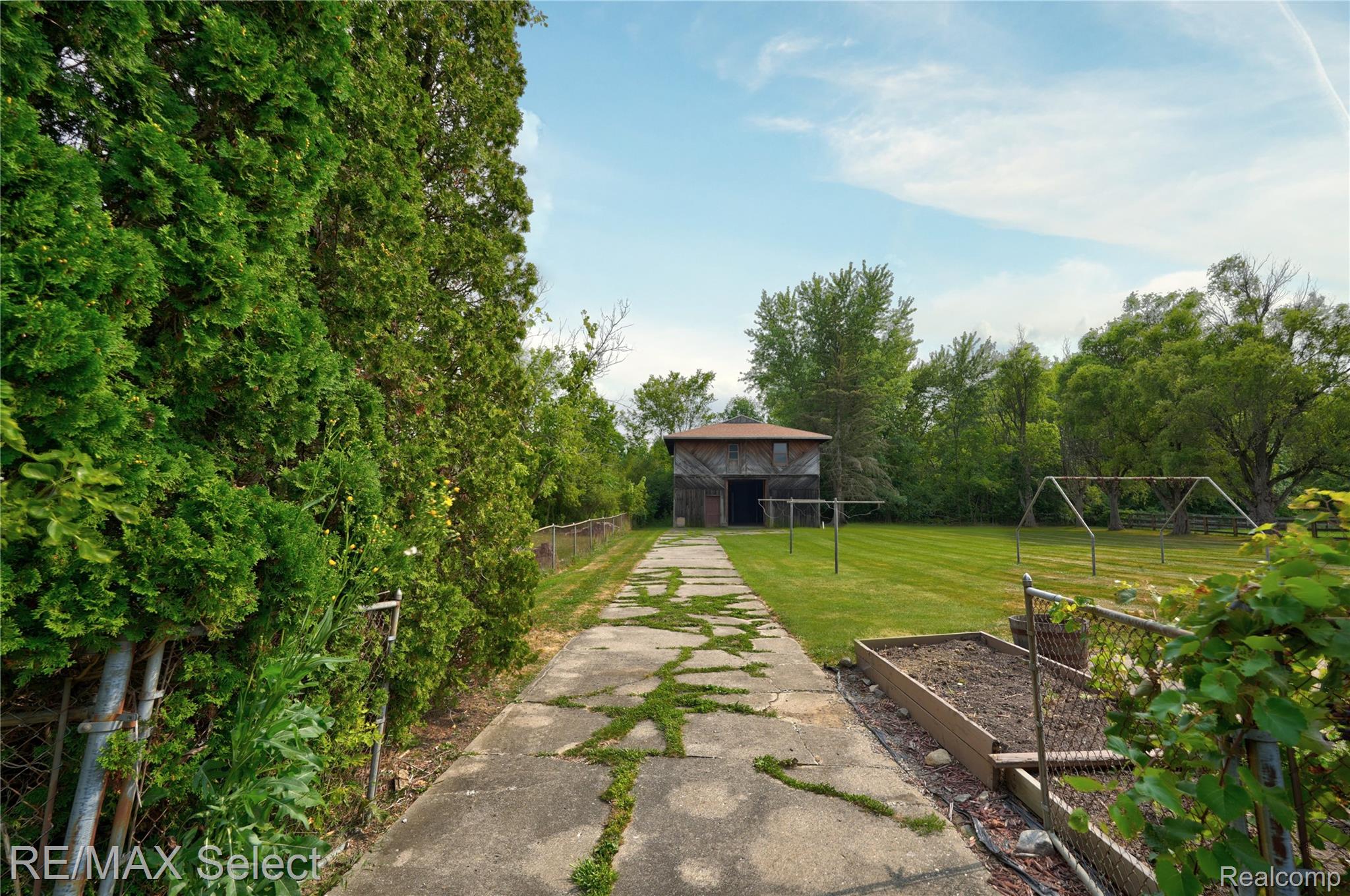 11080 Lapeer Road Davison, MI 48423 - Photo 20 of 64 Expansive green lawn, mature trees, concrete pathway, and a detached outbuilding
