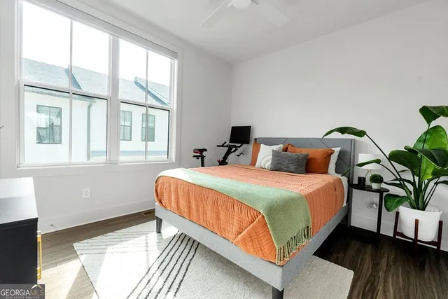 a bedroom with a bed lamp and a potted plant